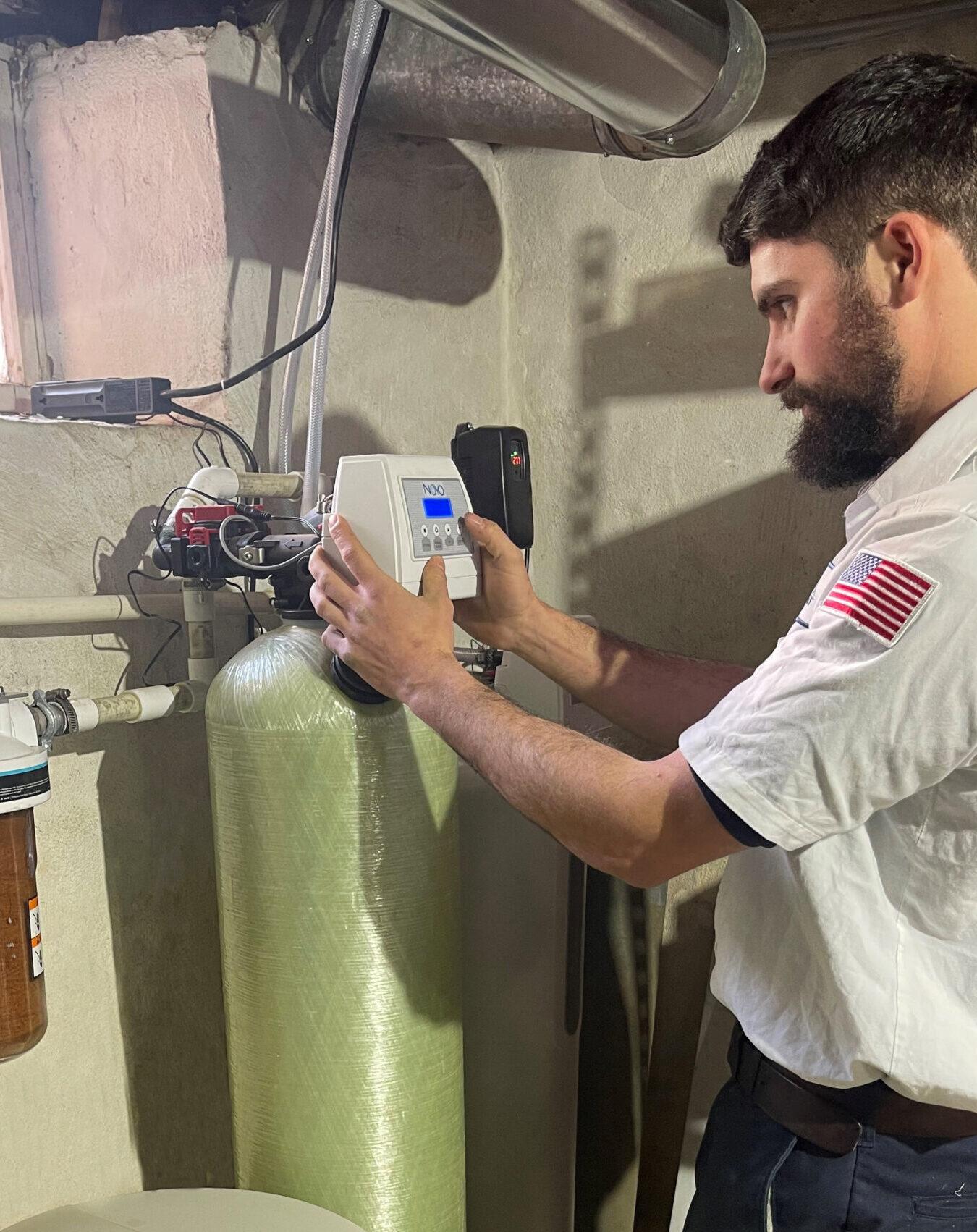Image of a plumber working on a water conditioner